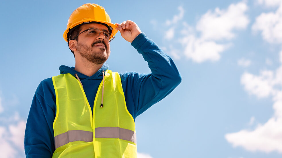 Male worker with hard hat and vest Construction e1734730870124